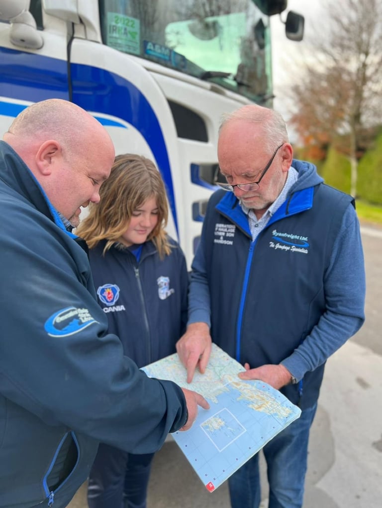 Three people in blue uniforms reviewing a map in front of a blue and white service vehicle